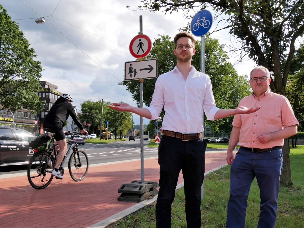 Nicolai Adler und André Langeworth stehen vor dem Verbotsschild für Fußgänger und fordern Nachbesserungen. (Foto: Lange)